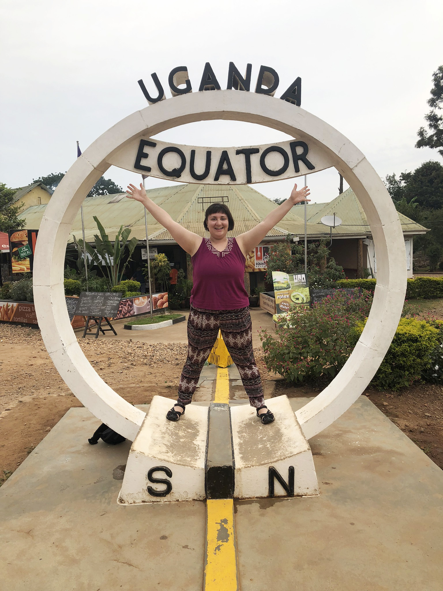 Julia Kramer inside a statue that says "Uganda Equator"