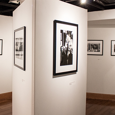 A view of a gallery with white walls displaying black and white photos of the civil rights era